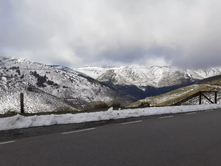 Paisaje montañoso nevado visto desde una carretera