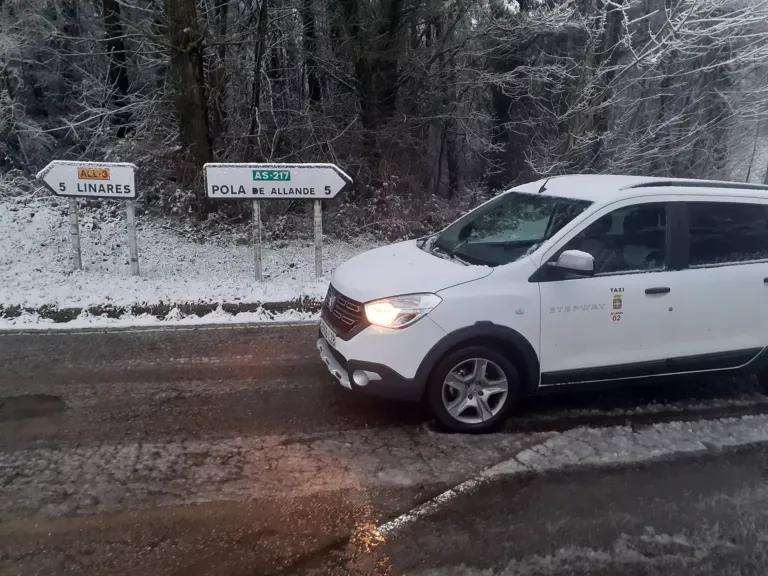 Taxi en un paisaje nevado junto a dos señales: 