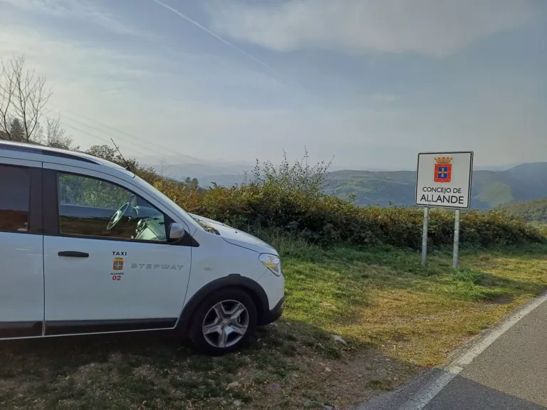 Taxi junto a una señal del Concejo de Allande